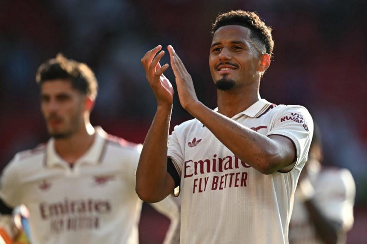 Arsenal's French defender #02 William Saliba applauds fans on the pitch after the English Premier League football match between Manchester United and Arsenal at Old Trafford in Manchester, north west England, on August 17, 2025. Arsenal won the game 1-0. Paul ELLIS / AFP