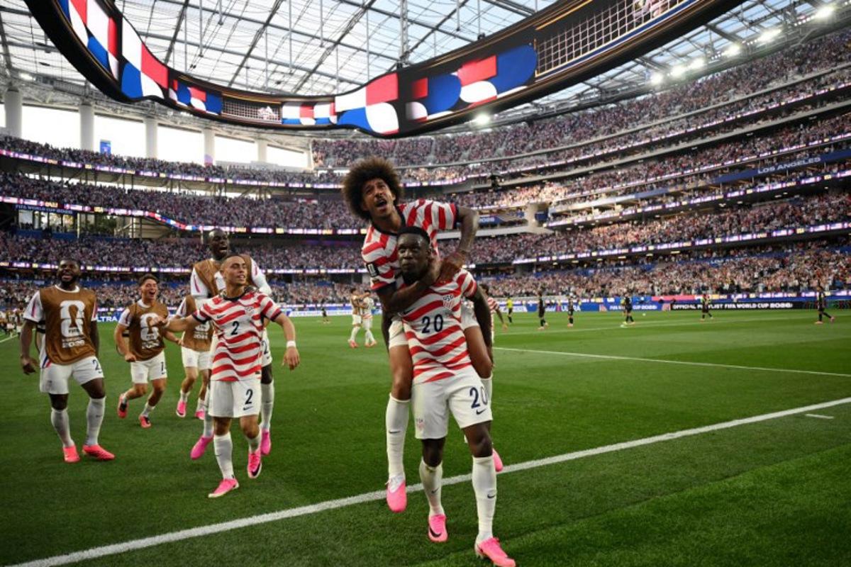 US forward #20 Folarin Balogun celebrates with teammates after scoring his team's third goal during the 2026 World Cup Group D football match between USA and Paraguay at the Los Angeles Stadium in Inglewood on June 12, 2026.  Patrick T. Fallon / AFP