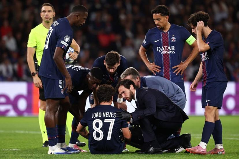 Paris Saint-Germain's Portuguese midfielder #87 Joao Neves (C) sits on the pitch as he receives medical attention during the UEFA Champions League first round day 1 football match between Paris Saint-Germain (FRA) and Atalanta (ITA) at the Parc des Princes stadium in Paris on September 17, 2025.  FRANCK FIFE / AFP