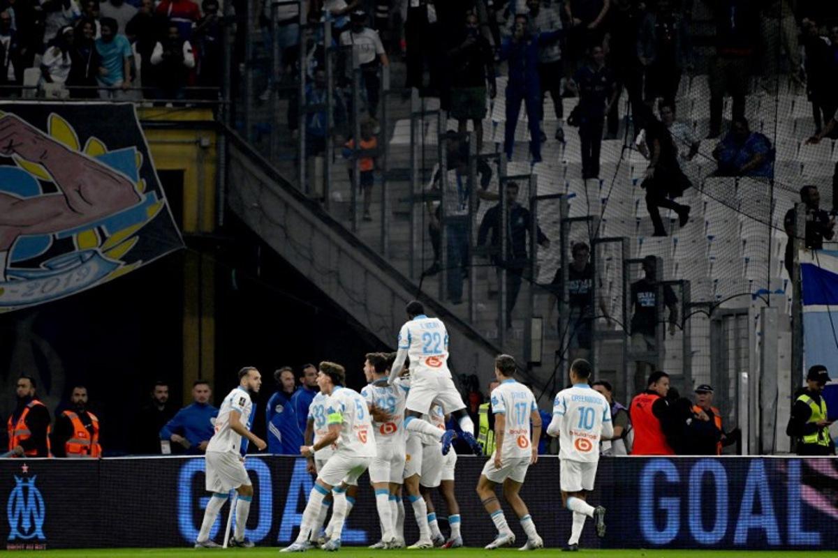 Marseille's players celebrate after scoring their first goal during the French L1 football match between Olympique de Marseille (OM) and Paris Saint-Germain (PSG) at the Velodrome stadium in Marseille on September 22, 2025.  Miguel MEDINA / AFP