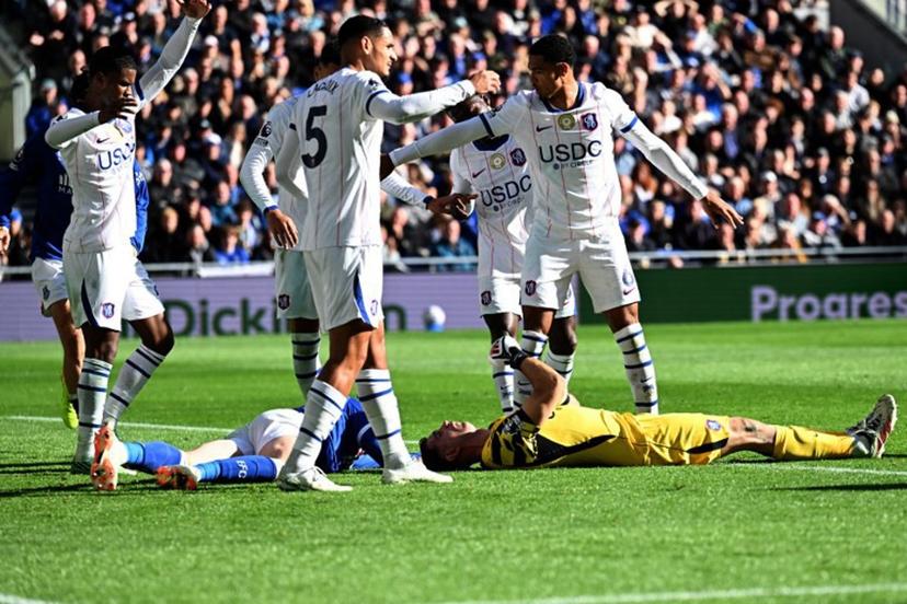 Chelsea's Argentinian goalkeeper #26 Emiliano Martinez and Everton's English defender #04 Jarrad Branthwaite lie injured after a clash during the English Premier League football match between Everton and Chelsea at Hill Dickinson Stadium in Liverpool, north west England on October 17, 2026.  PETER POWELL / AFP