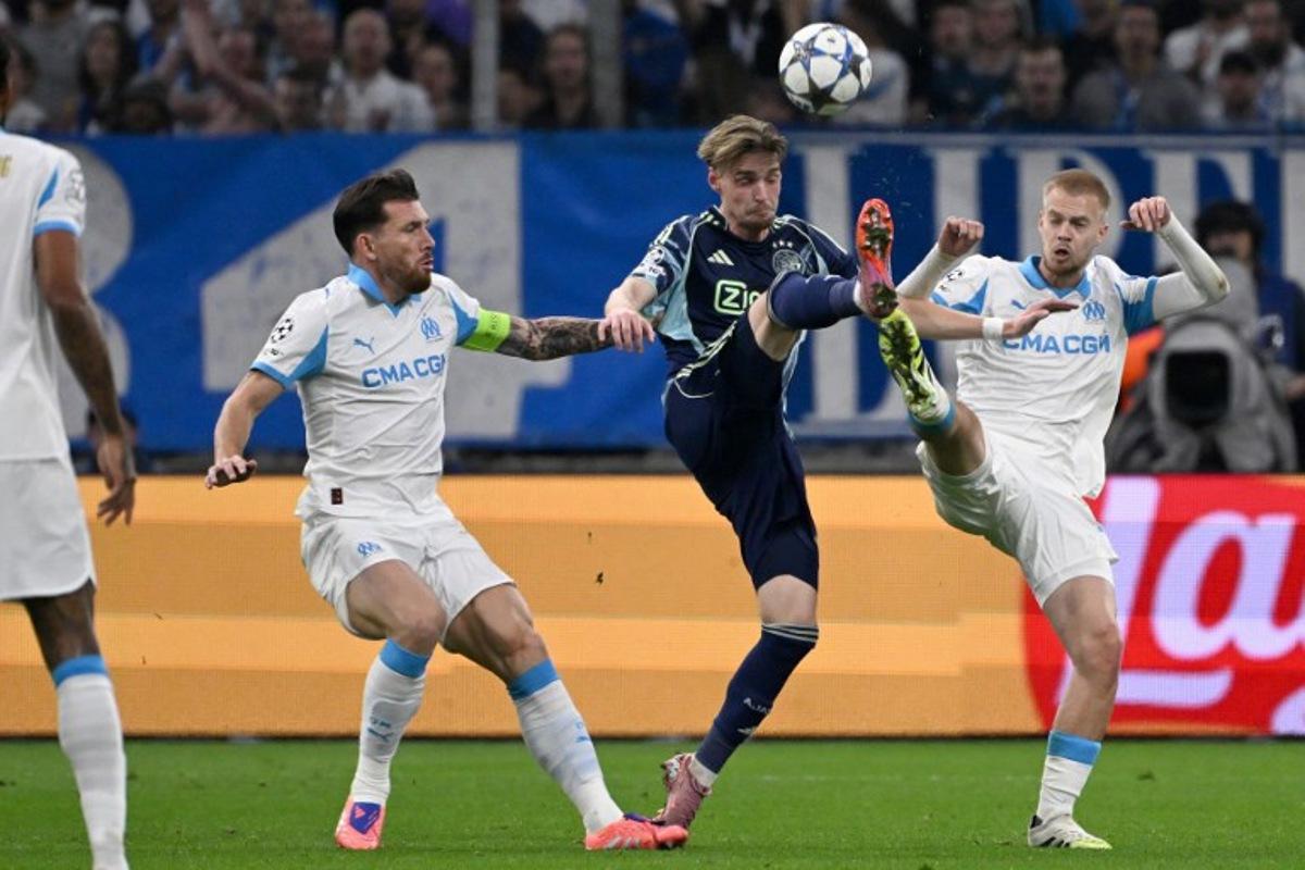 Ajax's Dutch midfielder #08 Kenneth Taylor (C) kicks the ball next to Marseille's Danish midfielder #23 Pierre-Emile Hojbjerg (L) and Marseille's Belgian midfielder #18 Arthur Vermeeren (R) during the UEFA Champions League, league phase day 2, football match between Olympique de Marseille (FRA) and AFC Ajax (NED) at the Velodrome stadium, in Marseille on September 30, 2025.  Miguel MEDINA / AFP