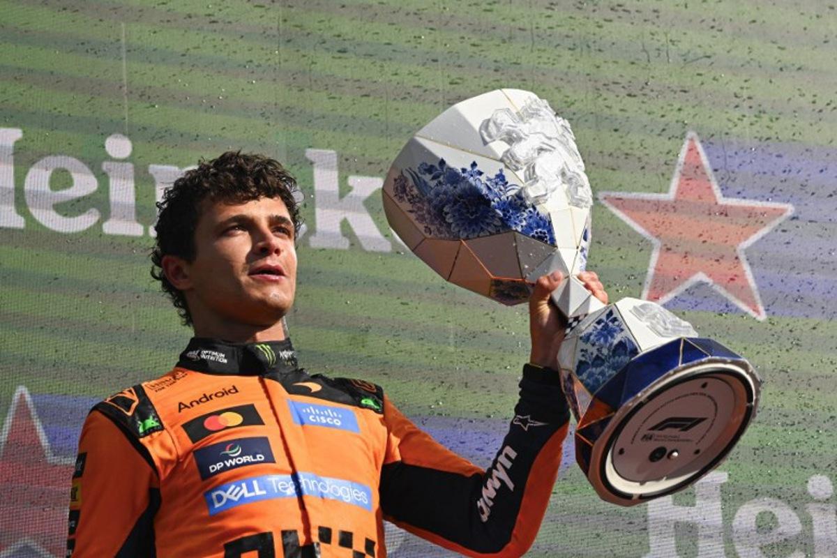 P1 McLaren's British driver Lando Norris celebrates with the trophy on the podium after the Formula One Dutch Grand Prix at The Circuit Zandvoort, western Netherlands, on August 23, 2026.  JOHN THYS / AFP