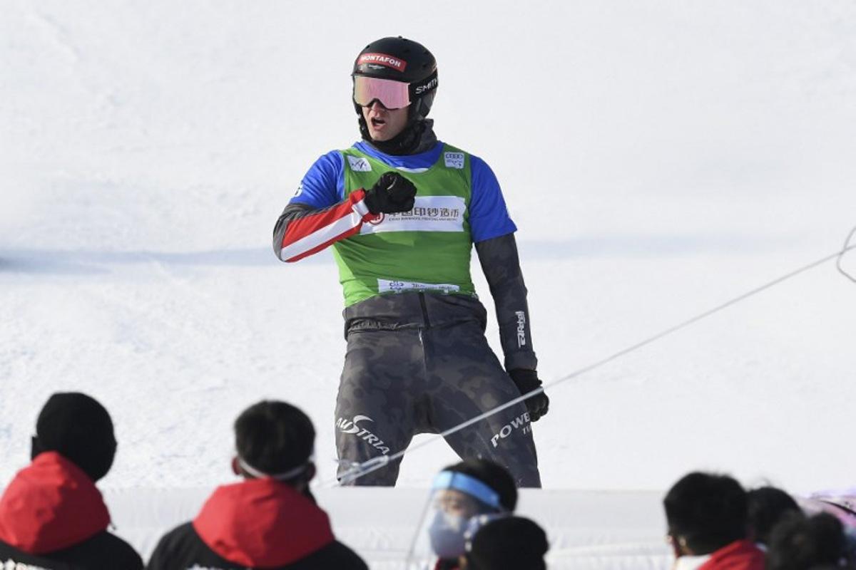 Austria's Alessandro Haemmerle celebrates after winning the men's snowboard cross finals during the FIS Snowboard Cross World Cup 2022, part of a 2022 Beijing Winter Olympic Games test event at the Genting Snow Park in Chongli county, Zhangjiakou city, China's Hebei province on November 28, 2021.   WANG Zhao / AFP