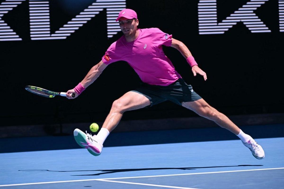 Belgium's Raphael Collignon hits a return against Italy's Lorenzo Musetti during their men's singles match on day three of the Australian Open tennis tournament in Melbourne on January 20, 2026.  WILLIAM WEST / AFP