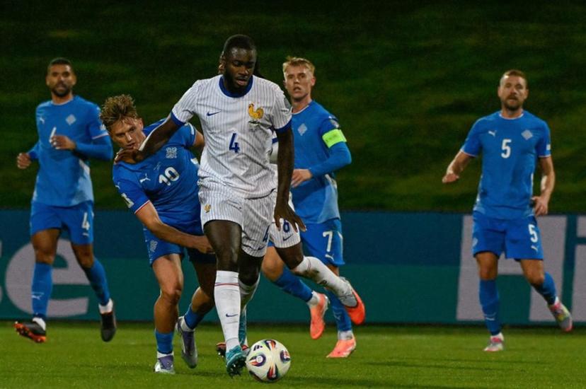 France's defender #04 Dayot Upamecano (C) and Iceland's forward #10 Albert Gudmundsson vie for the ball during the 2026 World Cup qualifying round Group D football match between Iceland and France at the Laugardalsvollur Stadium in Reykjavik on October 13, 2025.    Halldor KOLBEINS / AFP