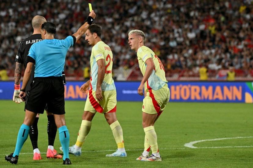 Dutch referee Serdar Gozubuyuk (2-R) gives a yellow card to Spain's forward #10 Dani Olmo (R) during the UEFA Nations League Group A4 football match between Serbia and Spain at the Rajko-Mitic stadium in Belgrade on September 5, 2024.  Andrej ISAKOVIC / AFP