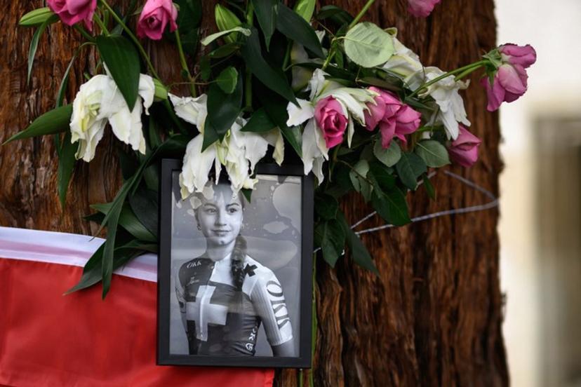This photograph shows a picture of late Swiss teenage cyclist Muriel Furrer and a Swiss flag at a makeshift altar in Zurich, on September 29, 2024, on the sidelines of the men's Elite Road Race cycling event during the UCI 2024 Road World Championships. Swiss teenage cyclist Muriel Furrer died on September 27, 2024 a day after suffering a serious head injury in a crash at the world championships. Fabrice COFFRINI / AFP