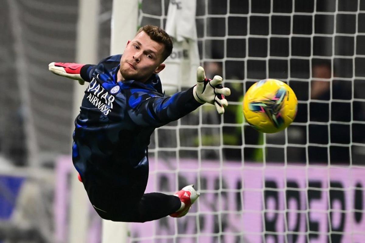 Inter Milan's Spanish goalkeeper #13 Josep Martínez attempts to catch the ball as he attends a warm up session prior to the Italian Serie A football match between Inter Milan and Genoa at San Siro stadium in Milan on February 22, 2025.  Piero CRUCIATTI / AFP