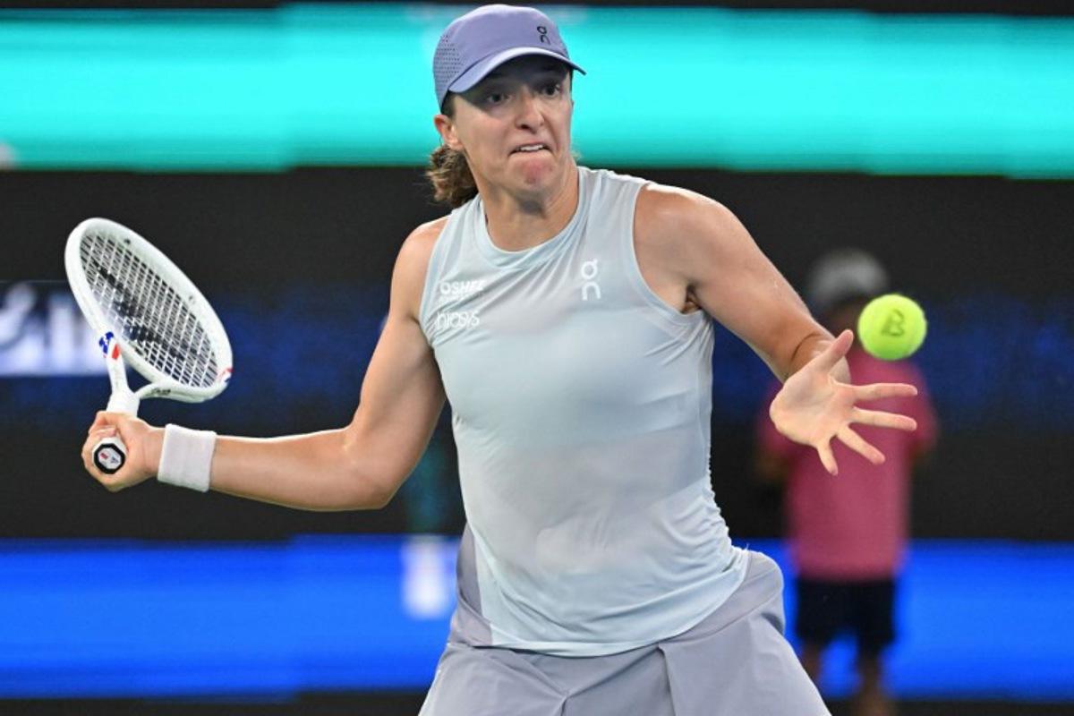 Poland's Iga Swiatek hits a return to Italy's Jasmine Paolini during their women's singles quarter-final match at the Wuhan Open tennis tournament in Wuhan, central China's Hubei province on October 10, 2025.  ADEK BERRY / AFP