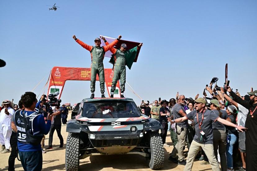 The Dacia Sandriders' Qatari driver Nasser al-Attiyah (R) and Belgian copilot Fabian Lurquin celebrate after winning the 48th edition of the Dakar Rally 2026 in Yanbu, Saudi Arabia, on January 17, 2026. Qatar's Nasser Al-Attiyah secured his sixth Dakar Rally car title in Saudi Arabia. Giuseppe CACACE / AFP