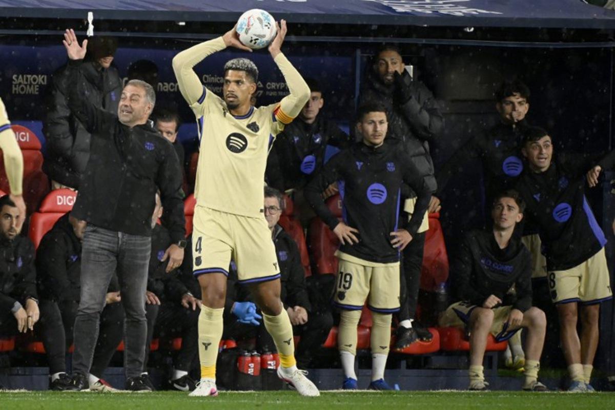 Barcelona's German coach Hans-Dieter Flick (L) gestures as Barcelona's Uruguayan defender #04 Ronald Federico Araujo da Silva takes a throw-in during the Spanish league football match between CA Osasuna and FC Barcelona at El Sadar Stadium in Pamplona on May 2, 2026.  ANDER GILLENEA / AFP