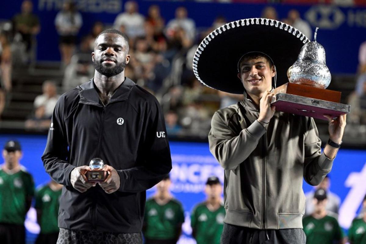 Italy's Flavio Cobolli (R) poses with his trophy after defeating US' Frances Tiafoe (L) during the 2026 Mexico ATP 500 Tennis Open men's singles tennis final match at the Arena GNP Seguros in Acapulco, Guerrero State, Mexico on February 28, 2026.  Alfredo ESTRELLA / AFP