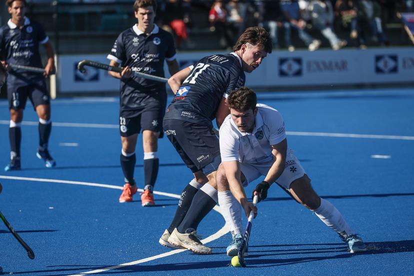 Gantoise's Etienne Tynevez and Braxgata's Ben Walker fight for the ball during a hockey game between Gantoise and Braxgata, Sunday 06 October 2024 in Gent, on day 5 of the Belgian first division hockey championship. BELGA PHOTO BRUNO FAHY