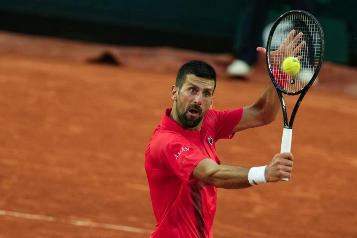 Serbia's Novak Djokovic plays a backhand return to win over France's Corentin Moutet during their men's singles match on day 5 of the French Open tennis tournament on Court Suzanne-Lenglen at the Roland-Garros Complex in Paris on May 29, 2025.  Dimitar DILKOFF / AFP