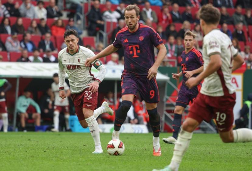 Bayern Munich's English forward #09 Harry Kane (C) and Augsburg's Swiss midfielder #32 Fabian Rieder (L) vie for the ball during the German first division Bundesliga football match between FC Augsburg and FC Bayern Munich in Augsburg, southern Germany on October 10, 2026.  Karl-Josef HILDENBRAND / AFP