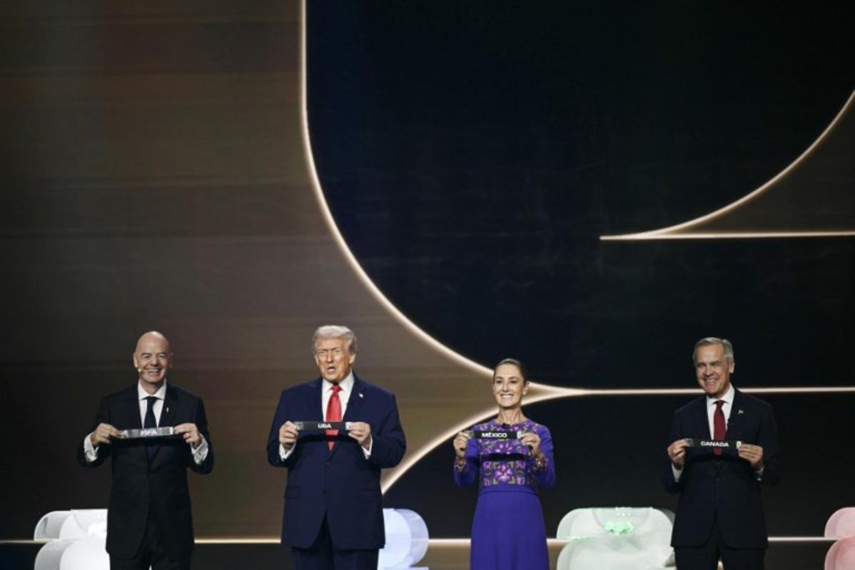(L-R) FIFA President Gianni Infantino, US President Donald Trump, Mexico's President Claudia Sheinbaum and Canada's Prime Minister Mark Carney hold cards on stage during the draw for the 2026 FIFA Football World Cup taking place in the US, Canada and Mexico, at the Kennedy Center, in Washington, DC, on December 5, 2025.  Brendan SMIALOWSKI / AFP