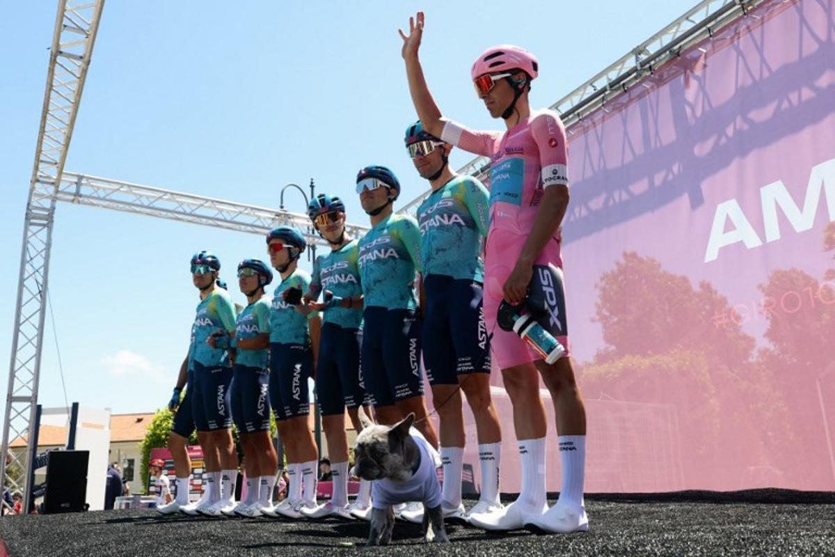 XDS Astana Team Uruguayan rider Guillermo Silva (R) wearing the overall leader's pink jersey (Maglia Rosa) holds his dog on a leash during the presentation prior the 4th stage of the Giro d'Italia 2026 - Tour of Italy cycling race between Catanzaro and Cosenza, Italy, on May 12, 2026.  Luca Bettini / AFP