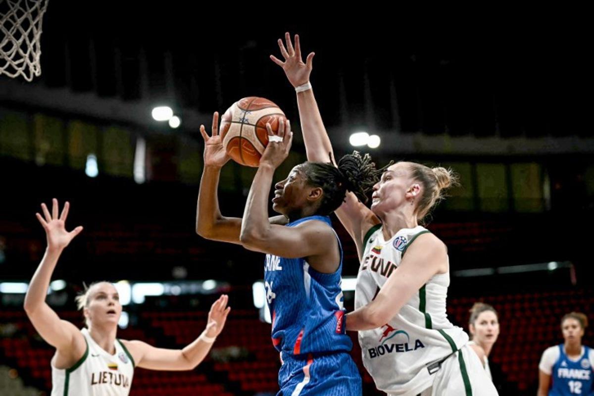 France's shooting guard Migna Toure (C) attempts a lay-up as she is defended by Lithuania's small forward Juste Jocyte (R) during the FIBA Women's EuroBasket 2025 quarter-final match between France and Lithuania at the Peace and Friendship Stadium in Athens on June 24, 2025.  Angelos Tzortzinis / AFP