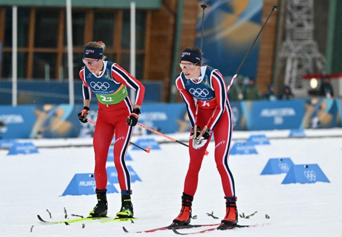 Norway's Kristin Austgulen Fosnaes (R) hands over the relay to Norway's Astrid Oeyre Slind during the cross-country women's 4 x 7,5km relay event of the Milano Cortina 2026 Winter Olympic Games at Tesero Cross-Country Skiing Stadium in Lago di Tesero (Val di Fiemme), on February 14, 2026.  Javier SORIANO / AFP