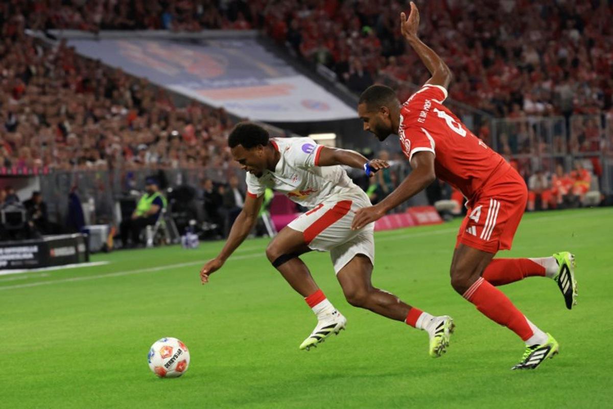 Leipzig's Belgian forward #11 Lois Openda (L) and Bayern Munich's German defender #04 Jonathan Tah vie for the ball during the German first division Bundesliga football match between FC Bayern Munich and RB Leipzig in Munich, southern Germany, on August 22, 2025.  Karl-Josef Hildenbrand / AFP