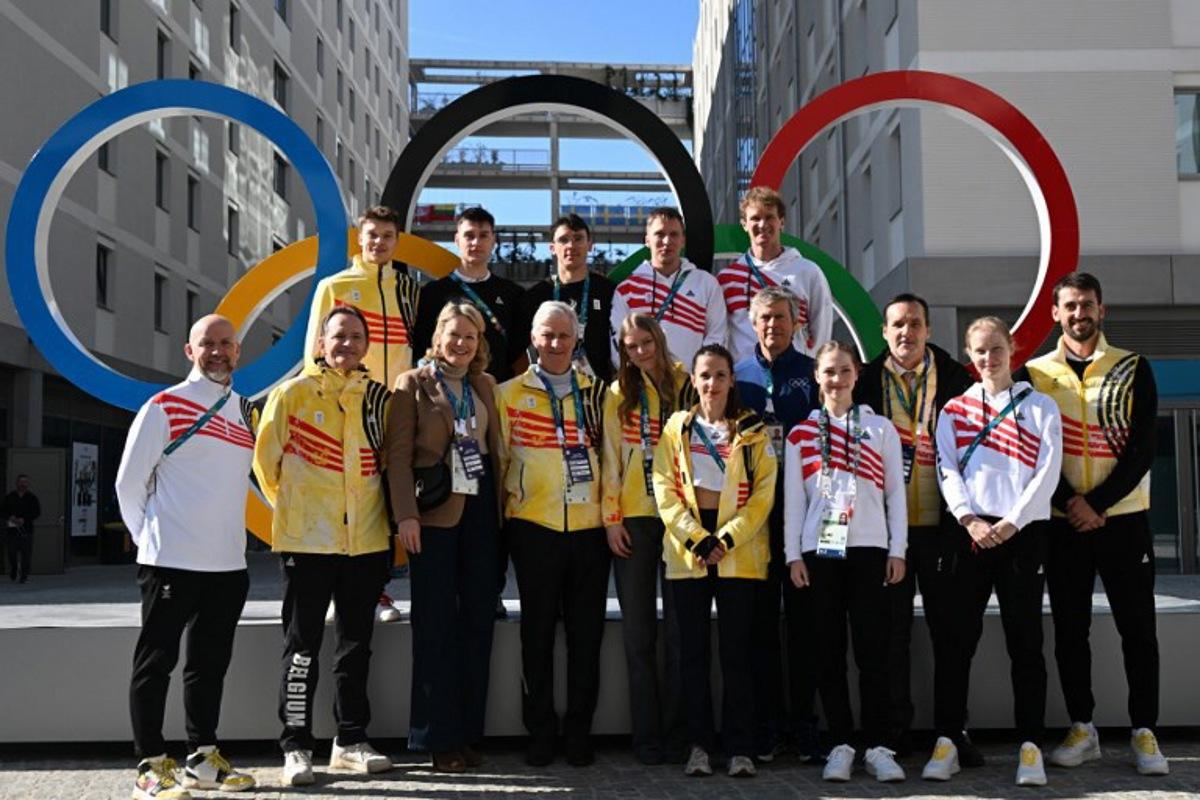 King Philippe - Filip of Belgium, Queen Mathilde of Belgium and Princess Eleonore (C) pose with Belgium's athletes Warre van Damme, Belgium's Adriaan Dewagtere, Stijn Desmet, Ward Petre, Hanne Desmet, Mathias Voste, Pierre-Olivier  Beckers-Vieujant, head of the IOC Coordination Commission for the 2030 Winter Olympics in France, Belgium's Nina Pinzarrone and Belgium's Tineke den Dulk as they visit the Olympic Village during the Milano Cortina 2026 Winter Olympics in Milan on February 21, 2026.  Daniel MUNOZ / POOL / AFP