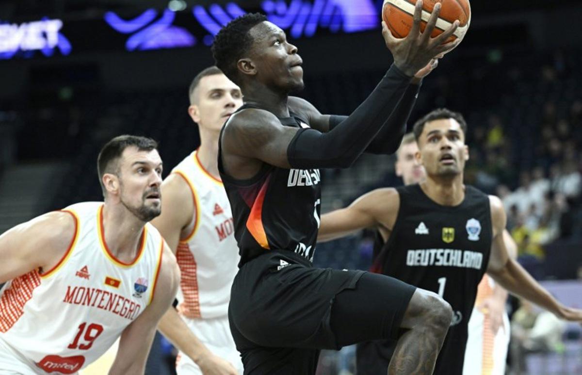 Germany's Dennis Schroder (C) and Montenegro's Zoran Nikolic (L) vie during the FIBA EuroBasket 2025 Group B basketball match between  Montenegro and Germany in Tampere, Finland, on August 27, 2025.  Heikki Saukkomaa / Lehtikuva / AFP