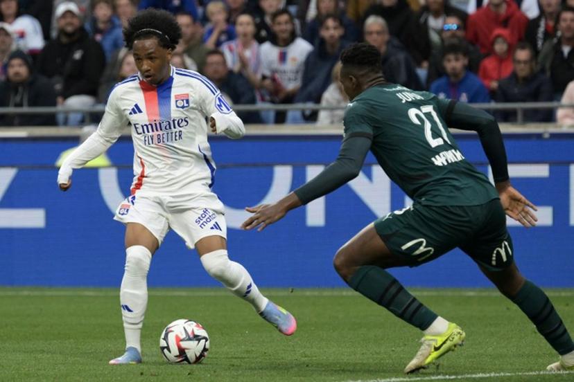 Lyon's Belgian forward #11 Malick Fofana (L) runs with the ball under pressure from Lens' Sierra Leonean defender #27 Juma Bah (R) during the French L1 football match between Olympique Lyonnais (OL) and RC Lens at Parc Olympique Lyonnais in Decines-Charpieu, central-eastern France, on May 4, 2025.  JEAN-PHILIPPE KSIAZEK / AFP