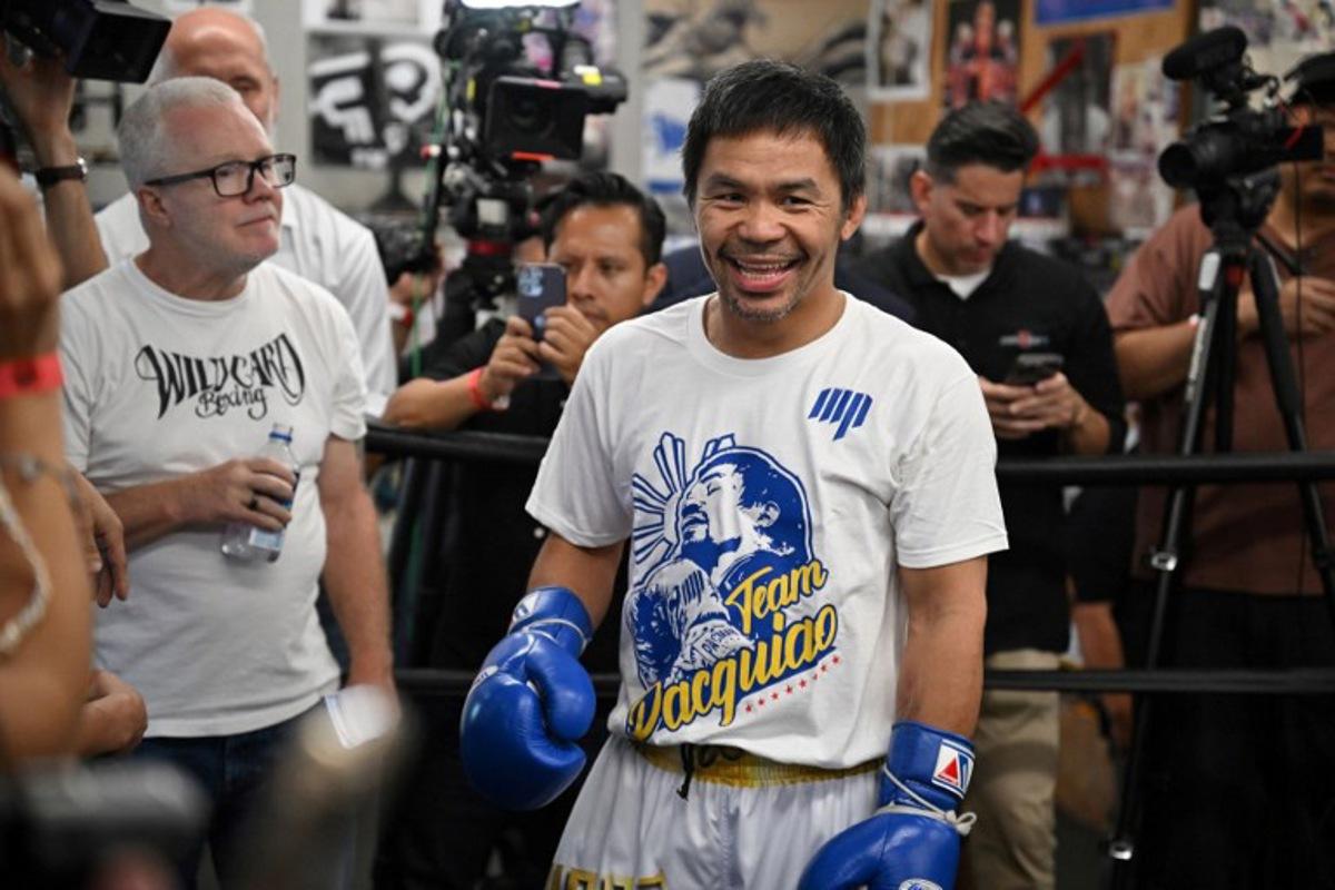 Trainer trainer Freddie Roach (L) looks on as Fillipino boxer Manny "Pacman" Pacquiao smiles during a media day workout at Wild Card Boxing Club in Los Angeles on June 25, 2025. Manny Pacquiao will take on US boxer Mario "El Azteca" Barrios for the WBC welterweight title on July 19, 2025, in Las Vegas, Nevada. Robyn Beck / AFP
