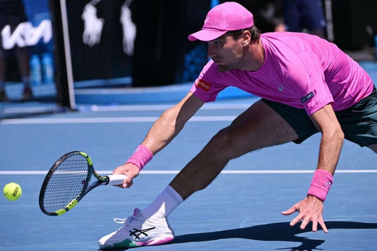 Belgium's Raphael Collignon hits a return against Italy's Lorenzo Musetti during their men's singles match on day three of the Australian Open tennis tournament in Melbourne on January 20, 2026.  WILLIAM WEST / AFP