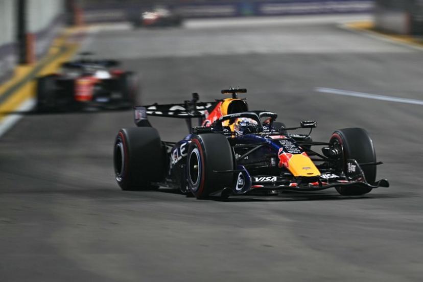 Red Bull Racing's Dutch driver Max Verstappen drives in front of Ferrari's Monegasque driver Charles Leclerc during the Formula One Singapore Grand Prix at the Marina Bay Street Circuit in Singapore on October 11, 2026.  ANTHONY WALLACE / AFP