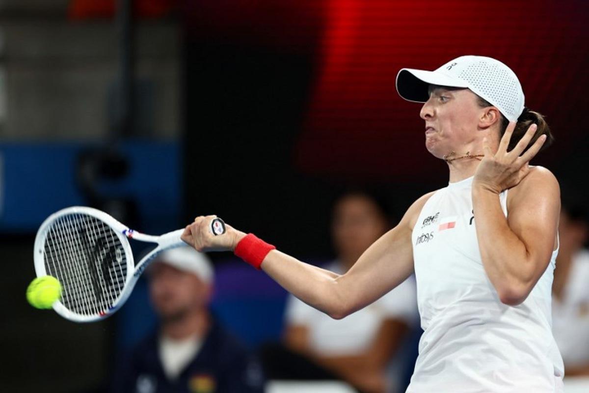 Poland's Iga Swiatek hits a return to Germany's Eva Lys during their women's singles match at the United Cup tennis tournament on Ken Rosewood Arena in Sydney on January 5, 2026.  Izhar KHAN / AFP