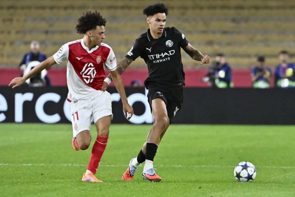 Monaco's French midfielder #11 Maghnes Akliouche (L) and Manchester City's English midfielder #33 Nico O'Reilly fight for the ball during the UEFA Champions League, league phase day 2, football match between Monaco and Manchester City at Stade Louis II, in Monaco on October 1, 2025.  FREDERIC DIDES / AFP