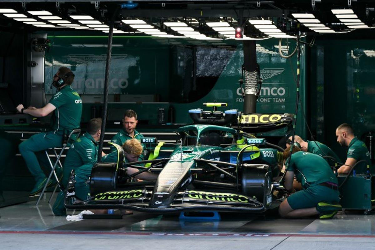 Aston Martin crew members work on the car of Aston Martin's Spanish driver Fernando Alonso ahead of the practice session for the United States Formula One Grand Prix at the Circuit of the Americas in Austin, Texas, on October 17, 2025.  RONALDO SCHEMIDT / AFP