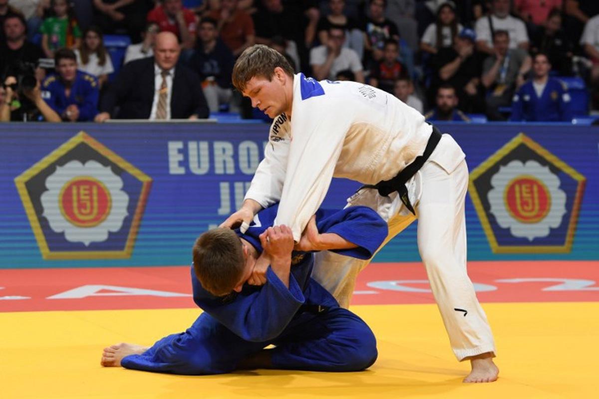 Germany's Fabian Kansy (Blue) and Belgium's Matthias Casse (White) compete in the men's -90 kg bout during the Judo's European Championships in Podgorica, on April 27, 2025. The tournament is taking place from April 23 to 27, 2025.   SAVO PRELEVIC / AFP