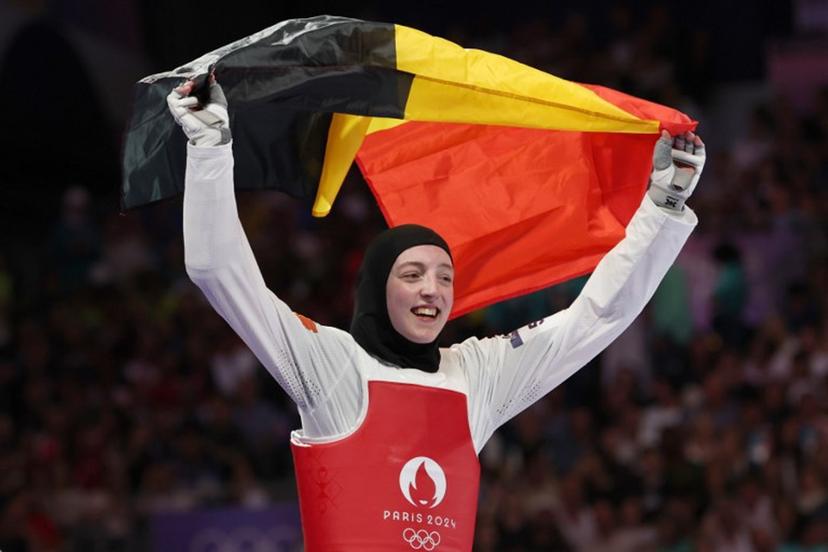 Belgium's Sarah Chaari celebrates with her country's flag after winning in the taekwondo women's -67kg bronze medal bout of the Paris 2024 Olympic Games at the Grand Palais in Paris on August 9, 2024.   David GRAY / AFP
