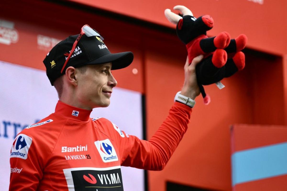 Team Visma-Lease a bike's Danish rider Jonas Vingegaard celebrates on the podium wearing the overall leader's red jersey after the third stage of the Vuelta a Espana, a 134 km race between San Maurizio Canavese and Ceres, in Italy's Piemonte region, on August 25, 2025.    Marco BERTORELLO / AFP