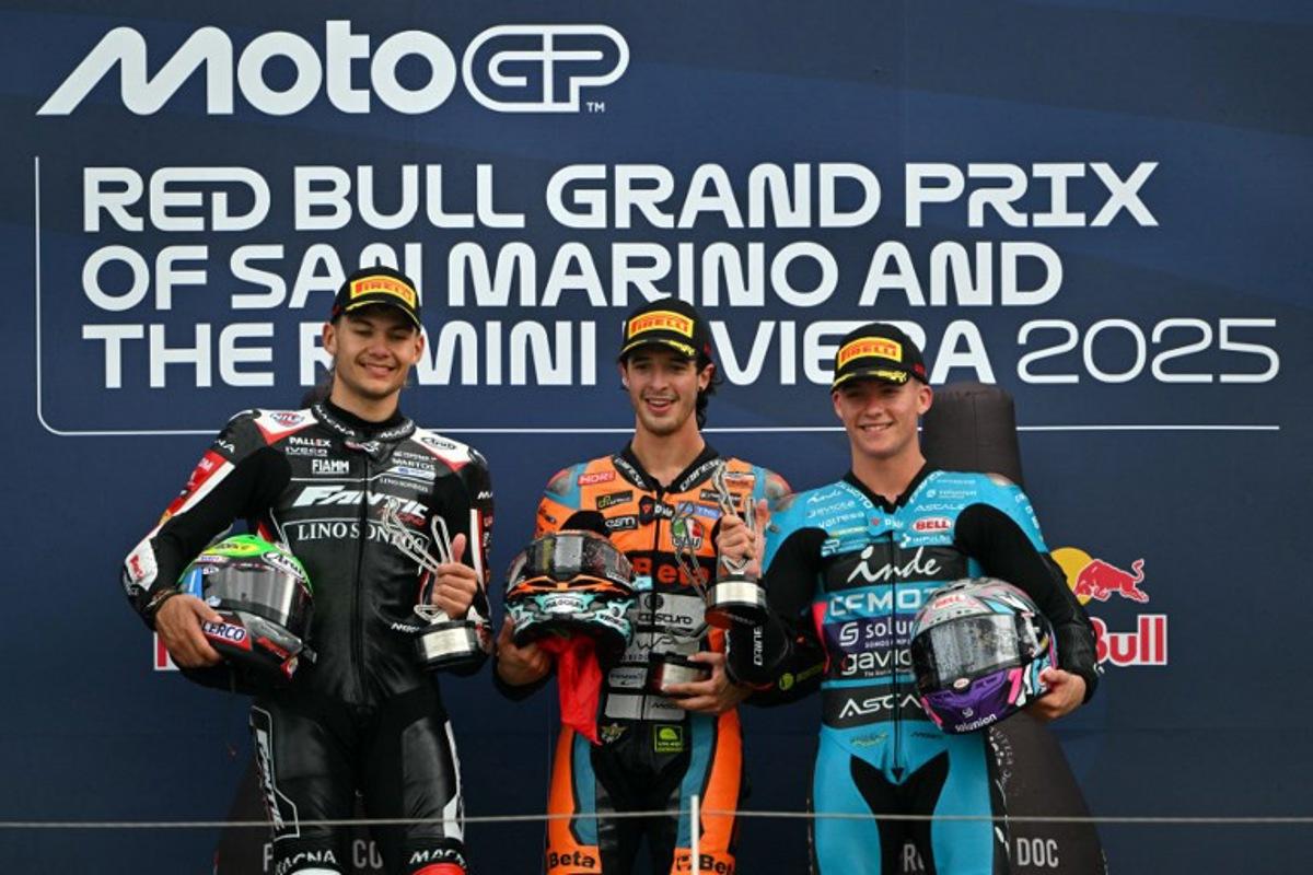 First placed Folladore SpeedRS Team's Italian Moto2 rider Celestino Vietti (C) stands on the podium next to Fantic Racing Lino Sonego team's Belgian Moto2 rider Barry Baltus (L) and thrid placed CFMOTO Inde Aspar Team's Spanish Moto2 rider Daniel Holgado (R) at the end of the Moto2 race as part of the San Marino Moto GP at the Misano World Circuit Marco Simoncelli, in Misano Adriatico, northern Italy, on September 14, 2025.  Andreas SOLARO / AFP