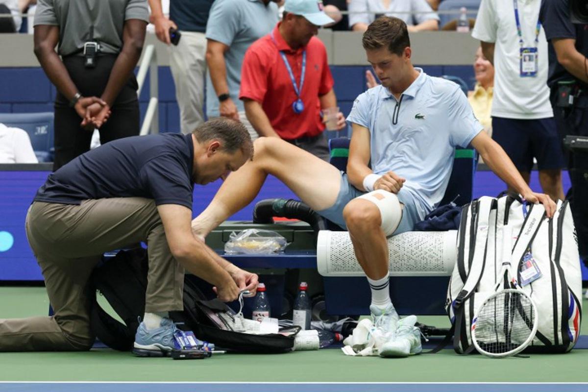 Belgium's Alexander Blockx receives medical attention as he plays Russia's Karen Khachanov in their men's singles quarter-final tennis match on day eleven of the US Open tennis tournament at the USTA Billie Jean King National Tennis Center in New York on September 9, 2026.  TIMOTHY A. CLARY / AFP