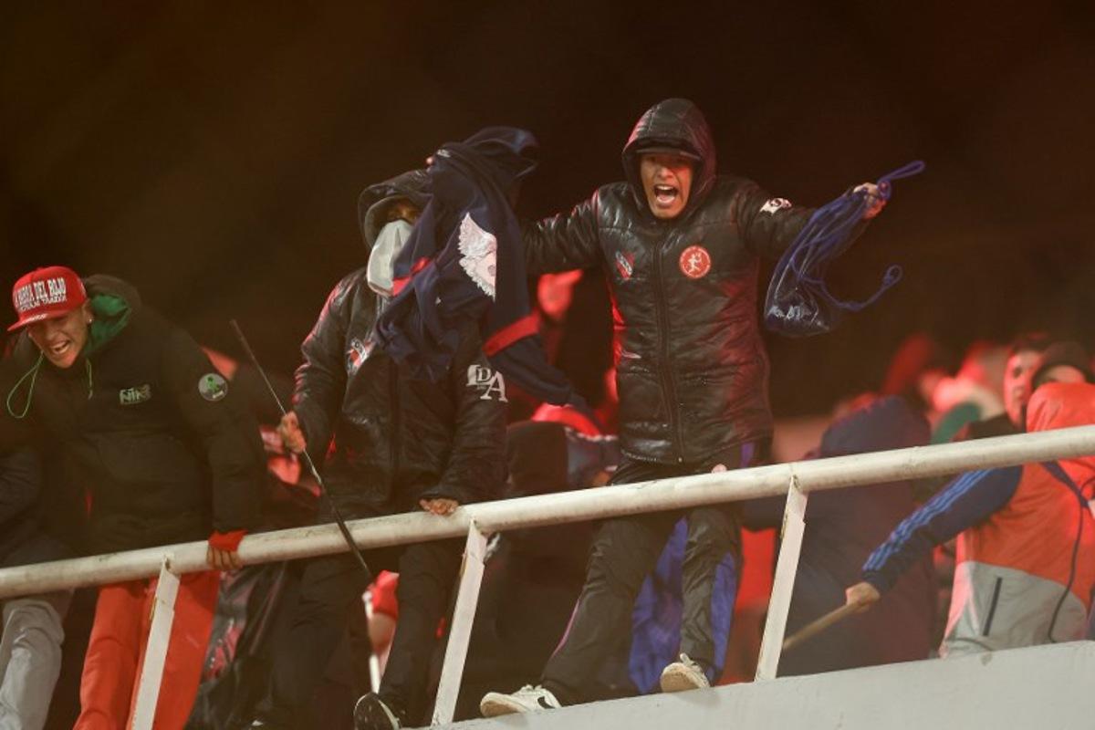 A fan of Independiente shouts during the interruption of the Copa Sudamericana round of 16 second leg football match between Argentina's Independiente and Chile's Universidad de Chile at the Libertadores de America stadium in Avellaneda, Buenos Aires province, Argentina on August 20, 2025. The match between Independiente and Universidad de Chile was suspended due to incidents in the stands during the second half, according to the Argentine club and confirmed by Conmebol. The score was tied 1-1. Alejandro PAGNI / AFP
