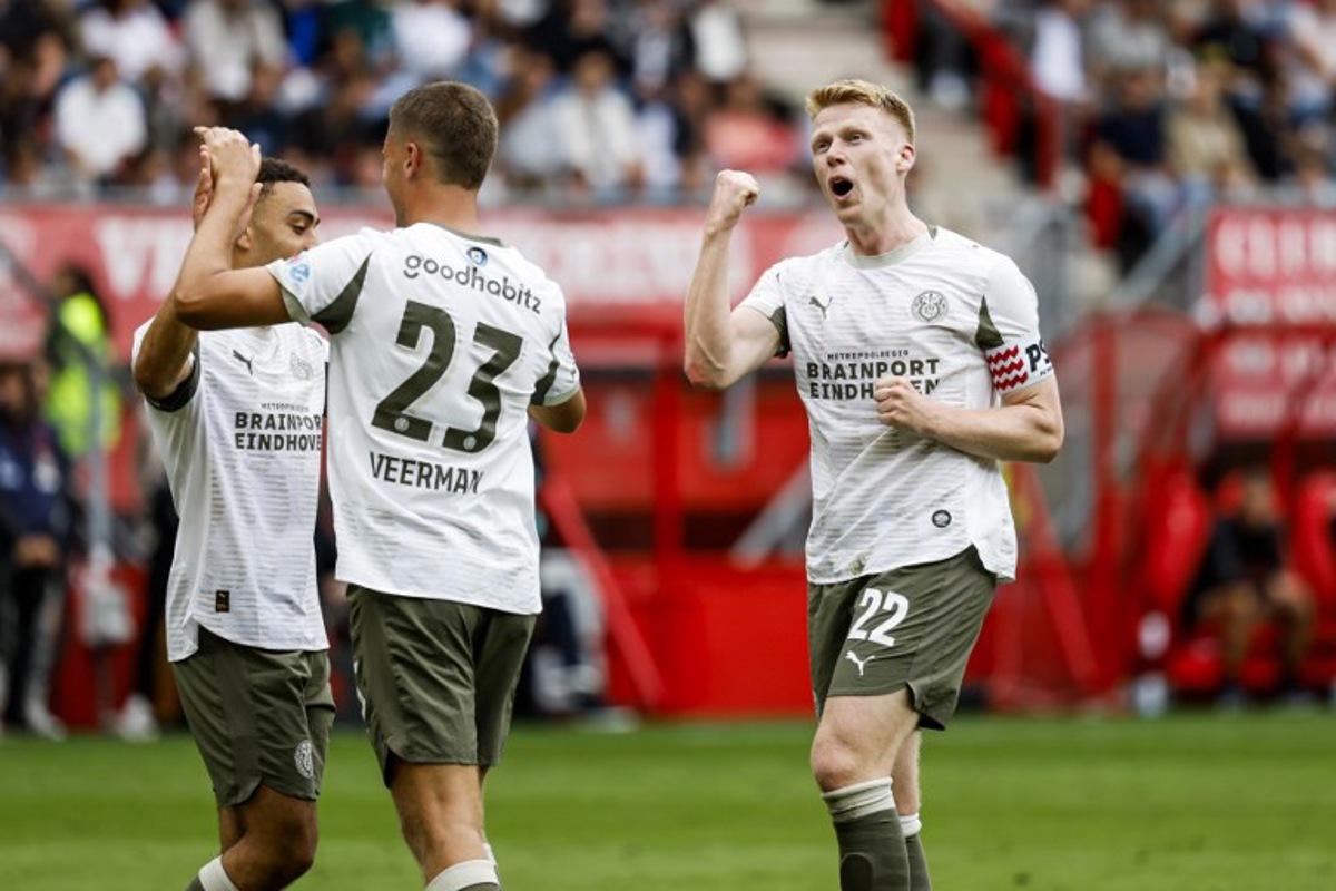 PSV Eindhoven's Dutch midfielder #22 Jerdy Schouten (R) celebrates his team's second goal during the Dutch Eredivisie football match between FC Twente and PSV Eindhoven at Philips Stadion in Eindhoven on August 17, 2025.  Vincent Jannink / ANP / AFP