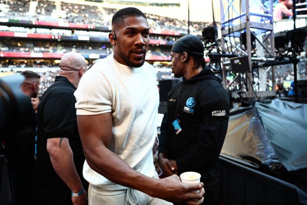 British boxer Anthony Joshua is seen ringside ahead of the heavyweight fight between Britain's Tyson Fury and Russia's Arslanbek Makhmudov at the Tottenham Hotspur stadium in London on April 11, 2026.  Henry NICHOLLS / AFP