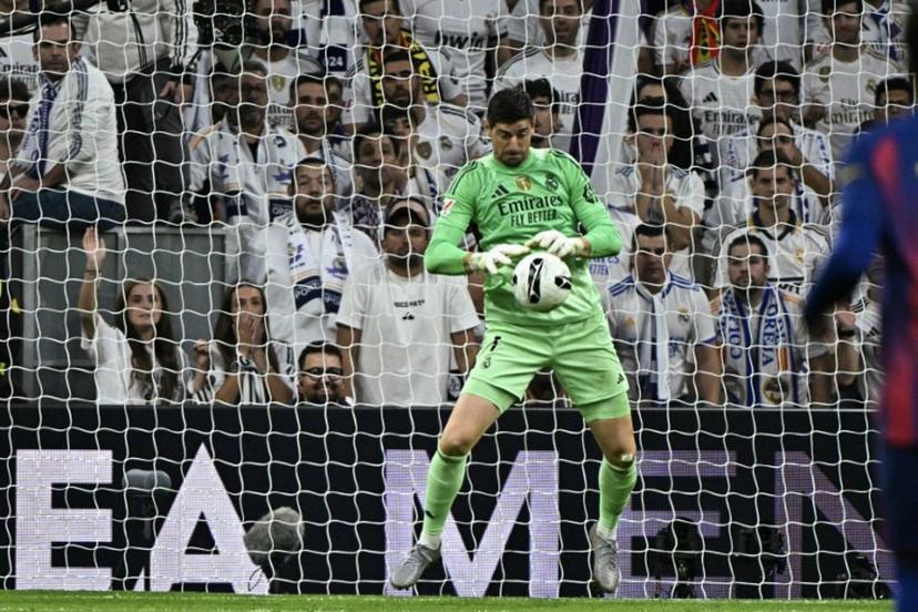 Real Madrid's Belgian goalkeeper #01 Thibaut Courtois stops a shot on goal during the Spanish league football match between Real Madrid CF and FC Barcelona at the Santiago Bernabeu stadium in Madrid on October 26 , 2025.  JAVIER SORIANO / AFP