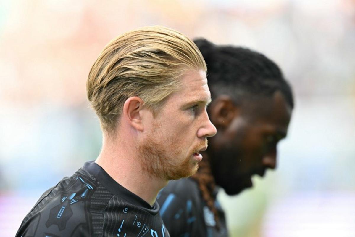 Napoli's Belgian midfielder #11 Kevin De Bruyne (L) looks on before the Italian Serie A football match between Sassuolo and Napoli at the Mapei - Città del Tricolore stadium in Reggio Emilia, on August 23, 2025.  Stefano RELLANDINI / AFP