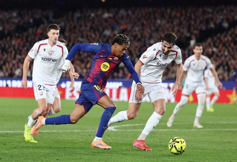 Barcelona's Spanish forward #10 Lamine Yamal fights for the ball with Osasuna's Spanish defender #24 Alejandro Catena as he attempts to score during the Spanish league football match between FC Barcelona and CA Osasuna at Camp Nou Stadium in Barcelona on December 13, 2025.  Josep LAGO / AFP