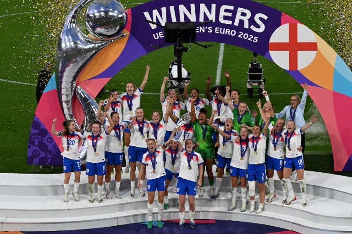 England's defender #06 Leah Williamson (CL) and England's midfielder #04 Keira Walsh (CR) lift the trophy as England celebrate winning the UEFA Women's Euro 2025 final football match between England and Spain at the St. Jakob-Park Stadium in Basel, on July 27, 2025.  Miguel MEDINA / AFP