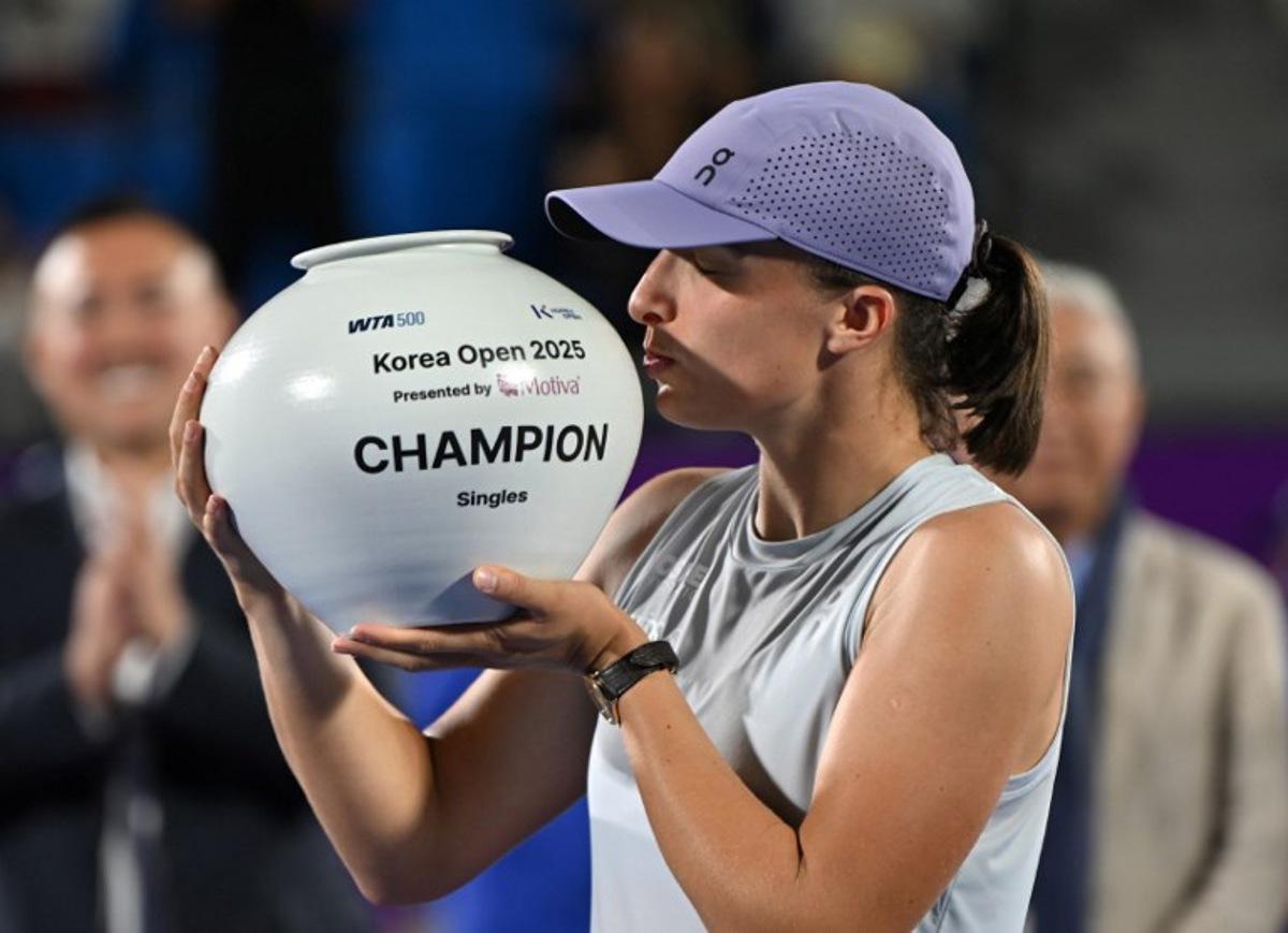 Iga Swiatek of Poland celebrates with the trophy after beating Ekaterina Alexandrova of Russia to win the women's singles final match at the Korea Open tennis tournament in Seoul on September 21, 2025.  Jung Yeon-je / AFP