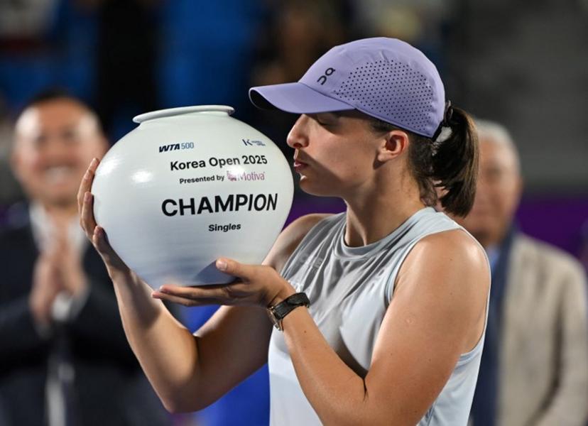 Iga Swiatek of Poland celebrates with the trophy after beating Ekaterina Alexandrova of Russia to win the women's singles final match at the Korea Open tennis tournament in Seoul on September 21, 2025.  Jung Yeon-je / AFP