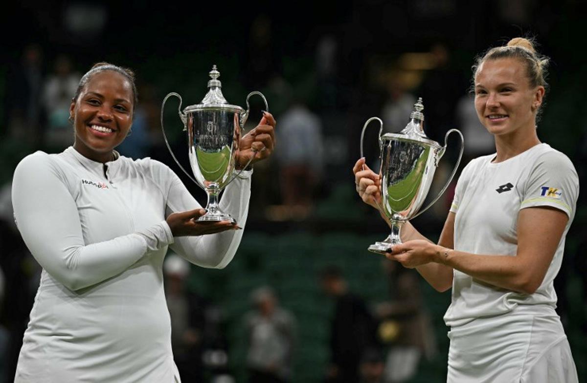 Winners USA's Taylor Townsend (L) and Czech Republic's Katerina Siniakova pose with their trophies following their victory against Canada's Gabriela Dabrowski and New Zealand's Erin Routliffe at the end of their women's doubles final tennis match on the thirteenth day of the 2024 Wimbledon Championships at The All England Lawn Tennis and Croquet Club in Wimbledon, southwest London, on July 13, 2024.  Ben Stansall / AFP