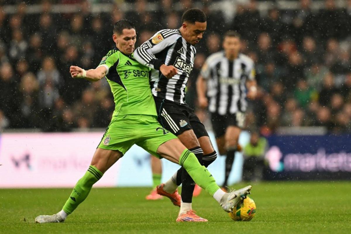 Fulham's Serbian midfielder #20 Sasa Lukic (L) tackles Newcastle United's English midfielder #41 Jacob Ramsey (R) during the English League Cup quarter-final football match between Newcastle United and Fulham at St James' Park in Newcastle-upon-Tyne, north east England on December 17, 2025.  Oli SCARFF / AFP